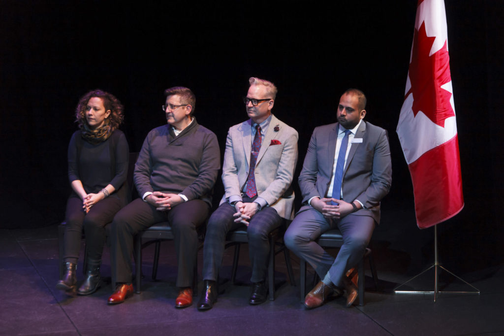 stage participants listen to MC