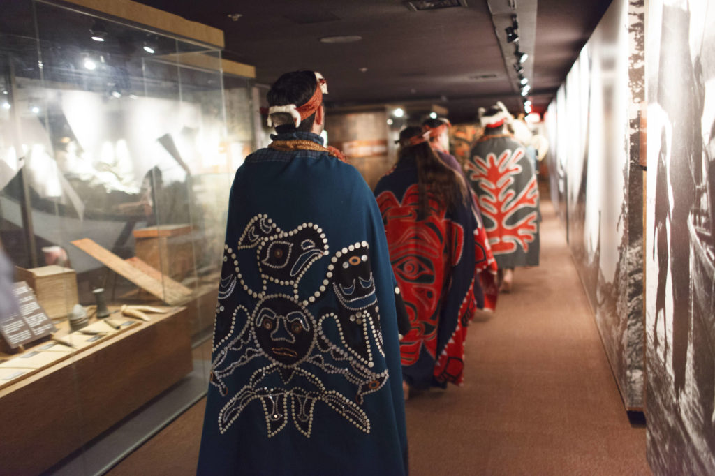 first nations performers walk through First House