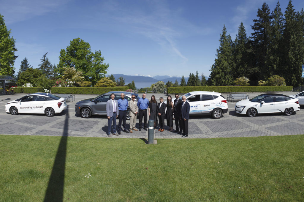 group photo in front of hydrogen fuel cars