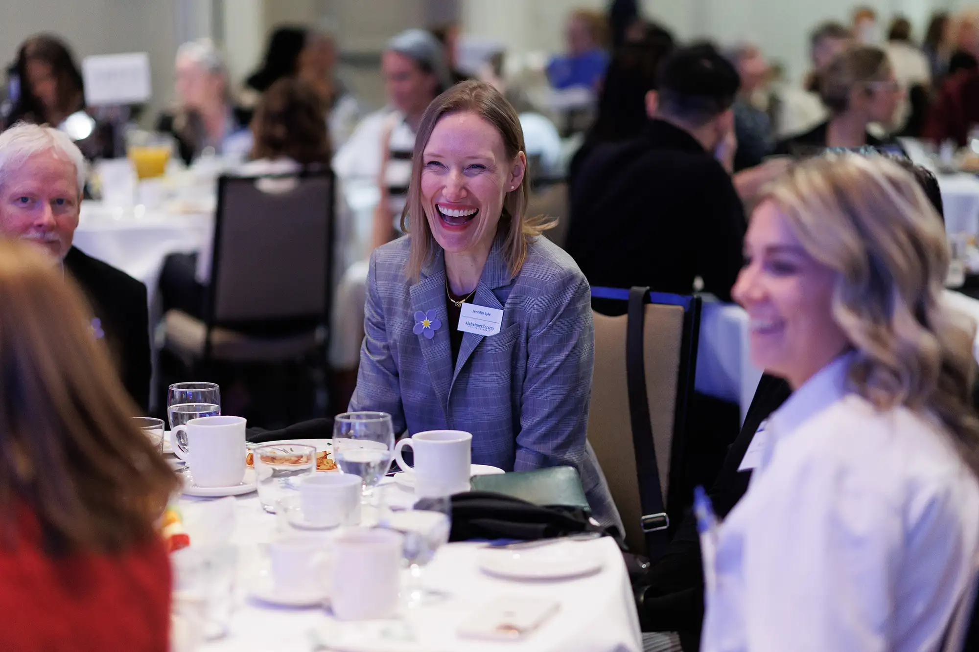 attendees at the BC Alzheimers fundraising event smile during their breakfast to remember