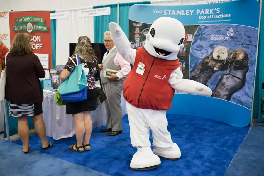 Vancouver Aquarium beluga mascot interacting with attendees at the CLIA Cruise Conference at Vancouver Convention Centre, captured by Victoria trade show photographer Geoff Howe.