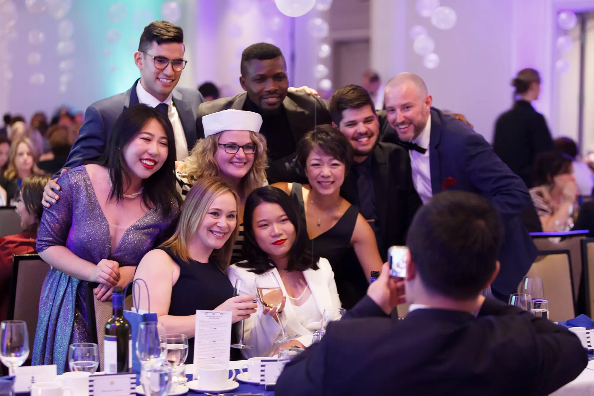 a group at an awards gala in Victoria, smiling while having their photo taken