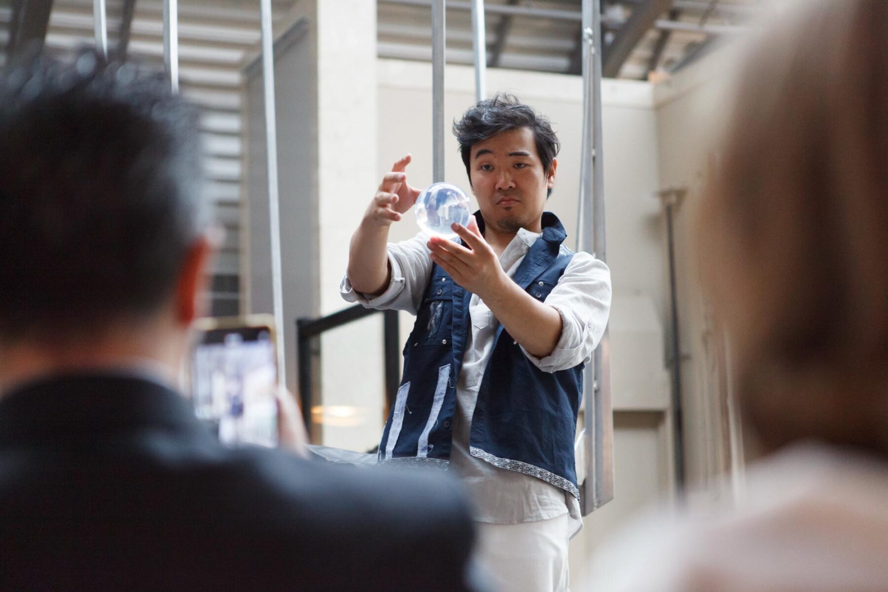 performance artist holding glass ball