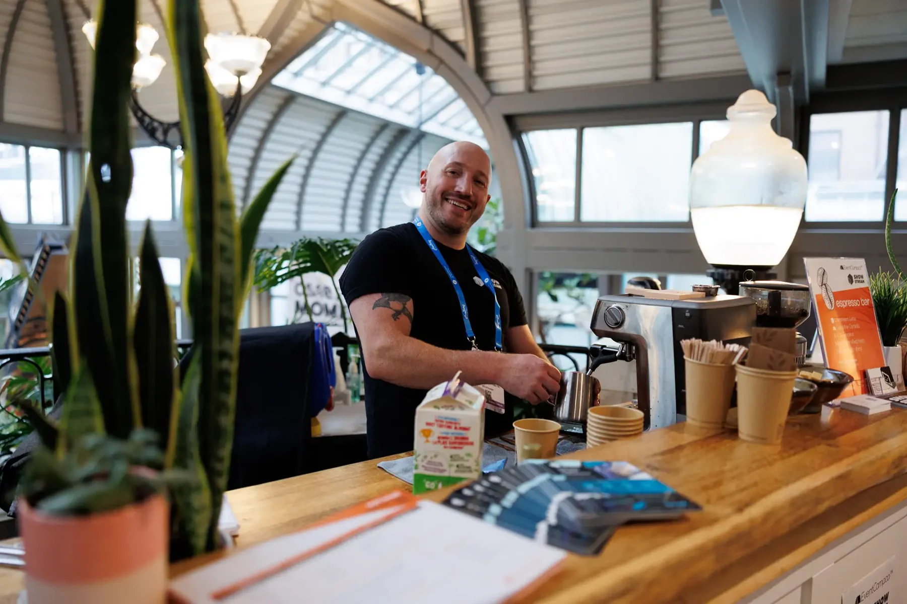 A vendor smiles at his booth during the CSAE 2025 conference in Victoria BC