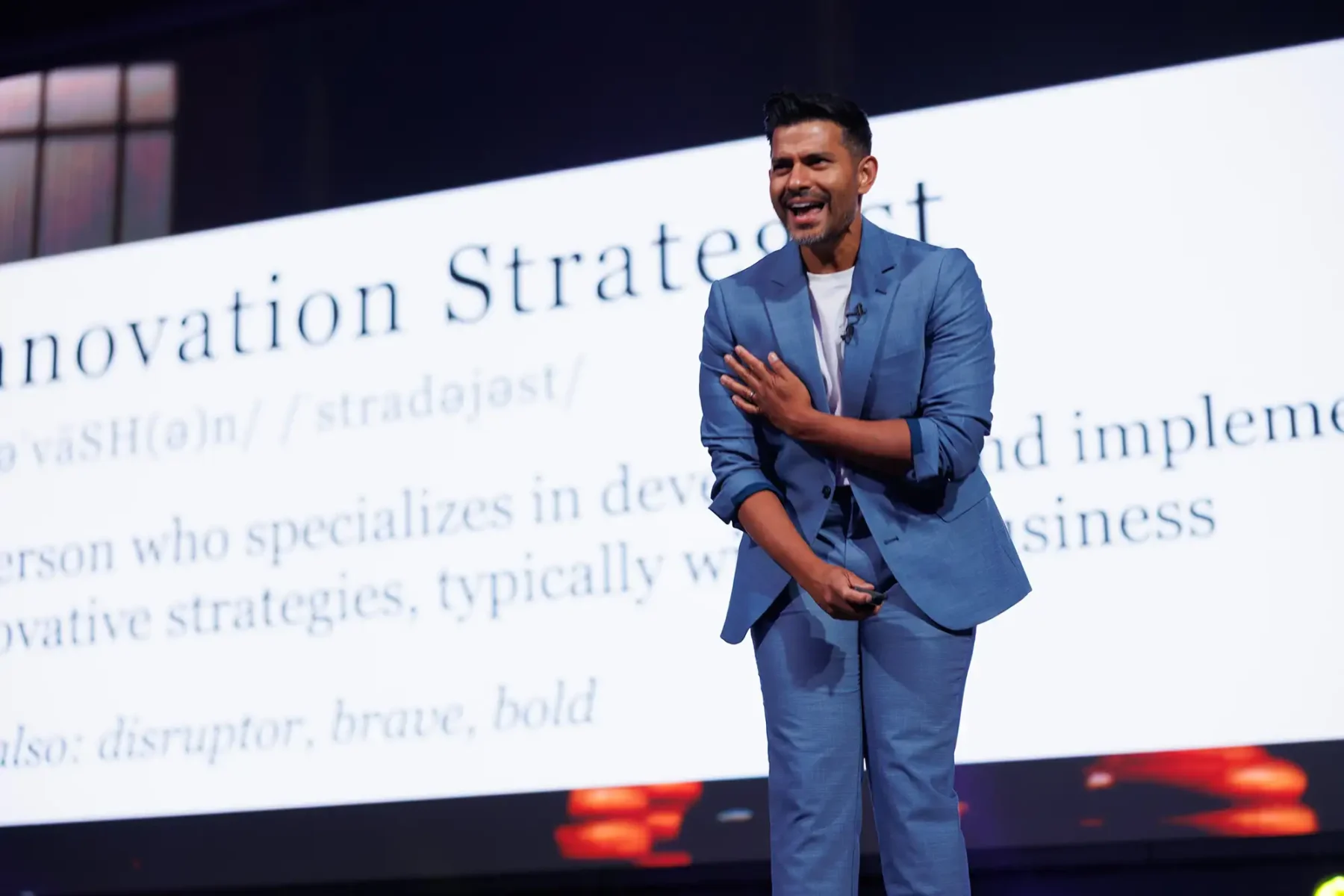 A keynote presenter smiles on stage while interacting with the audience during conference photography in Victoria BC