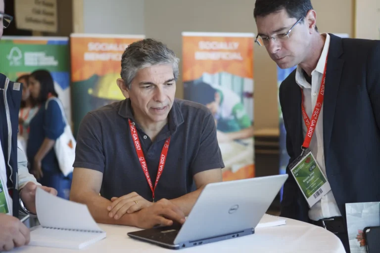 Two men reviewing a laptop at the FSC conference, showing event photography in Victoria BC