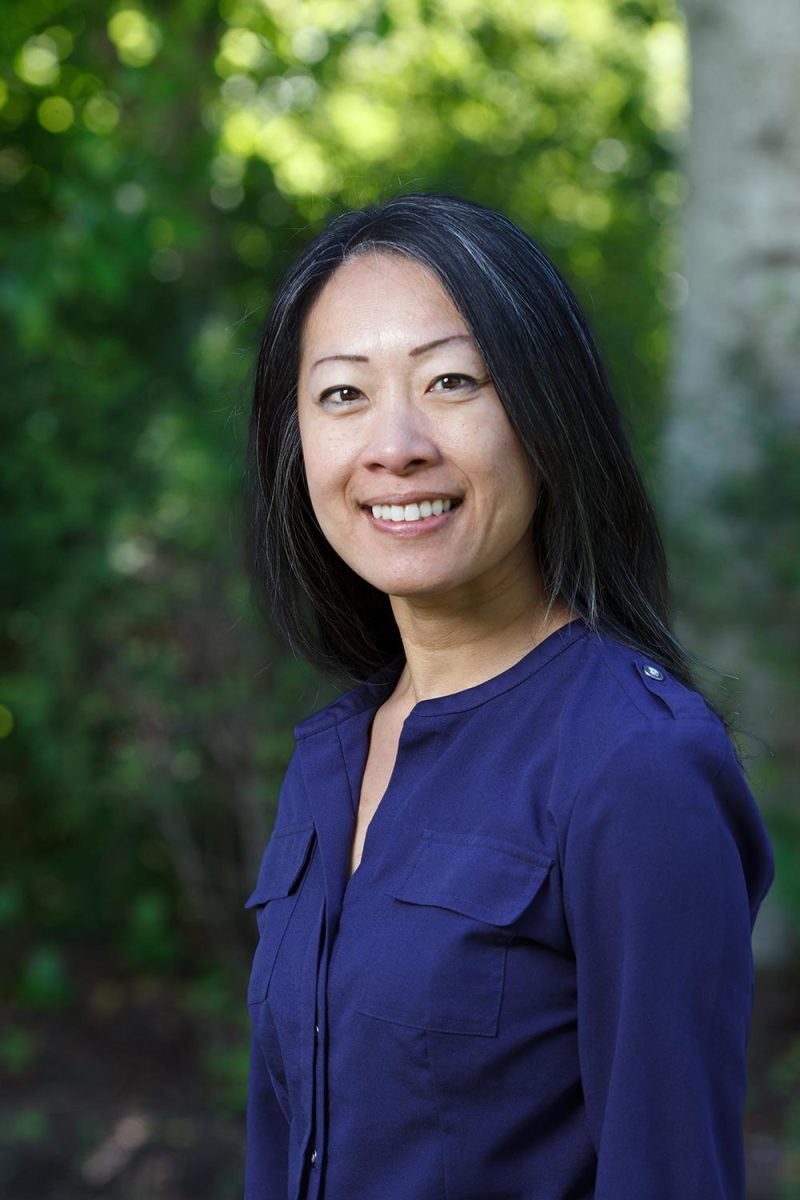 Outdoor executive portraits in Victoria BC of a woman next to green foliage