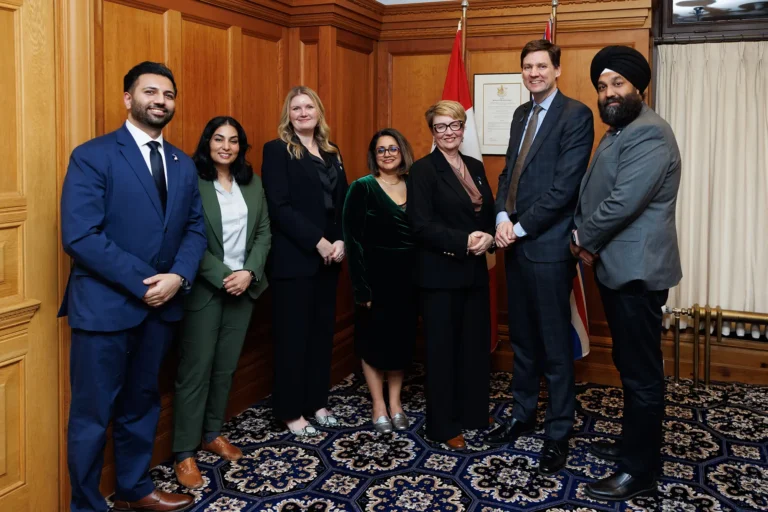 groupshot of an advocacy group posing with B.C. Premier David Eby