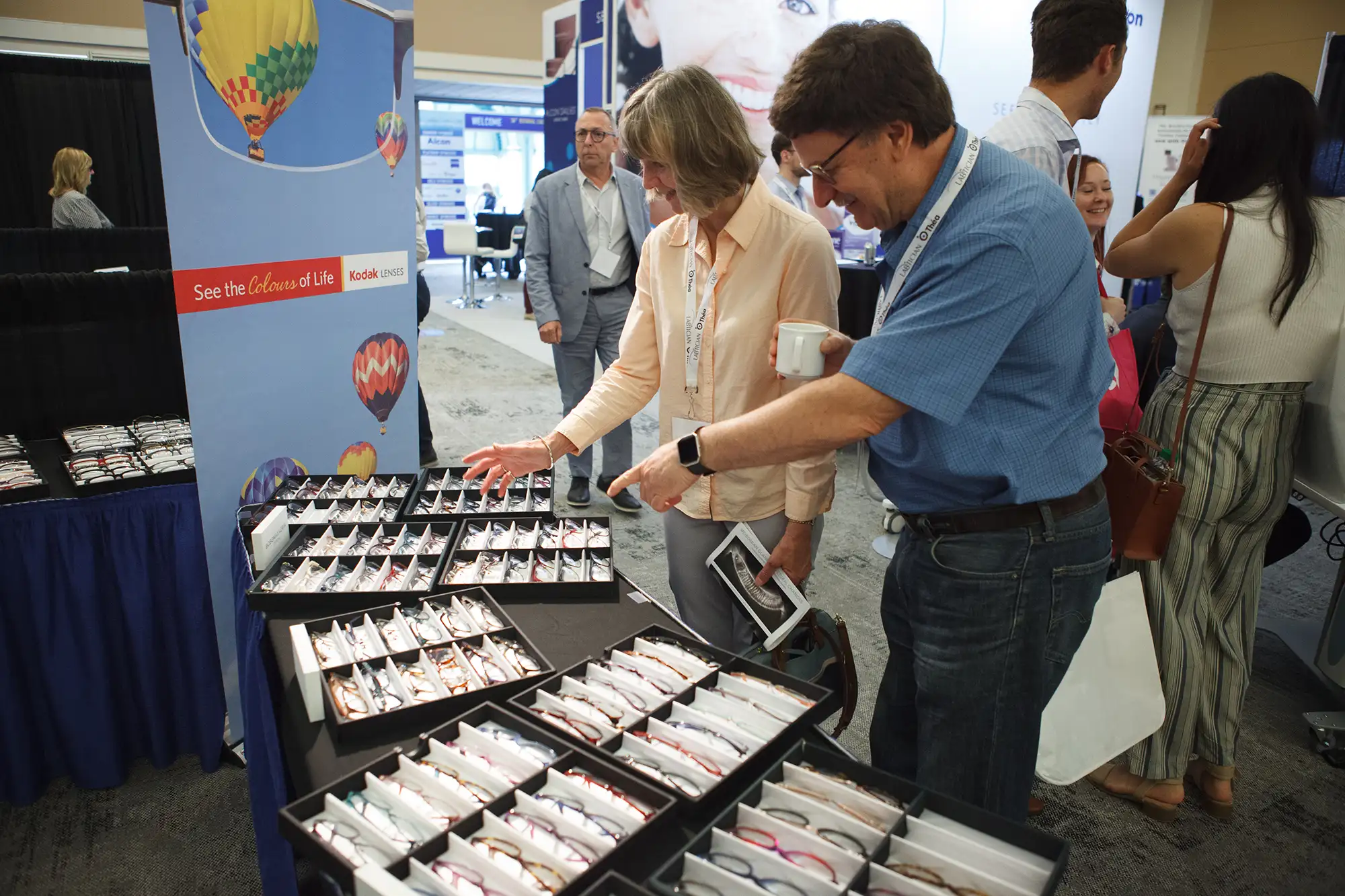 a man at an industry expo points towards products on the trade show floor