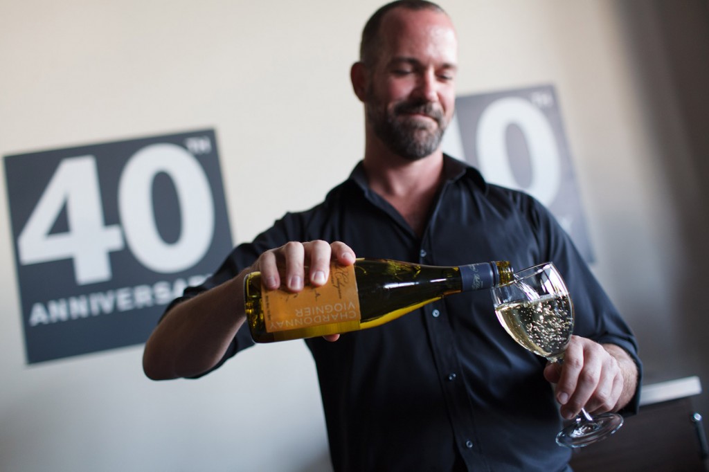 a bartender pours drinks with the kryton logo 40th behind him